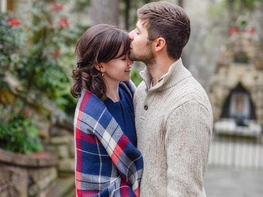 couple-kissing-plaid-blanket-outdoors
