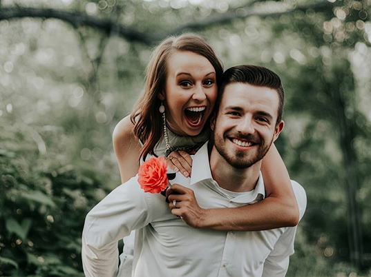 happy-couple-piggyback-outdoor-portrait
