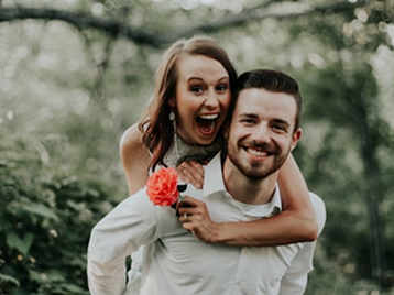 happy-couple-piggyback-outdoor-portrait