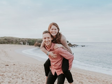 playful-couple-piggyback-seaside